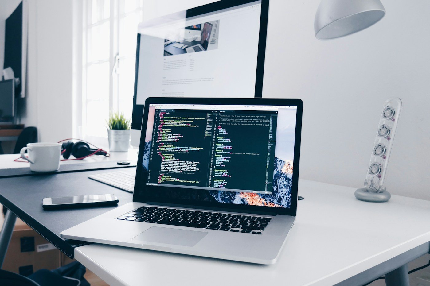 Illustrative development desk with code on a monitor